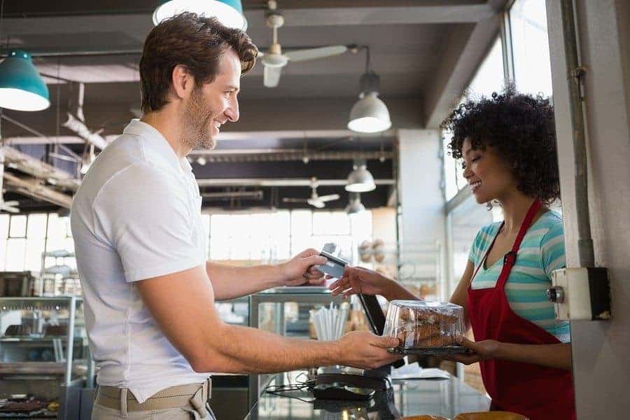 a person handing a credit card to a person 