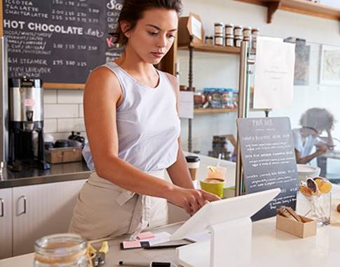 a person standing at a counter using laptop